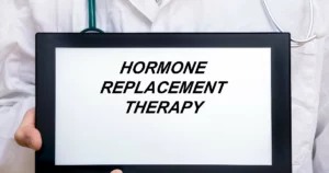 Doctor holding a tablet displaying the words representing Hormone Replacement Therapy (HRT) in Draper, UT.